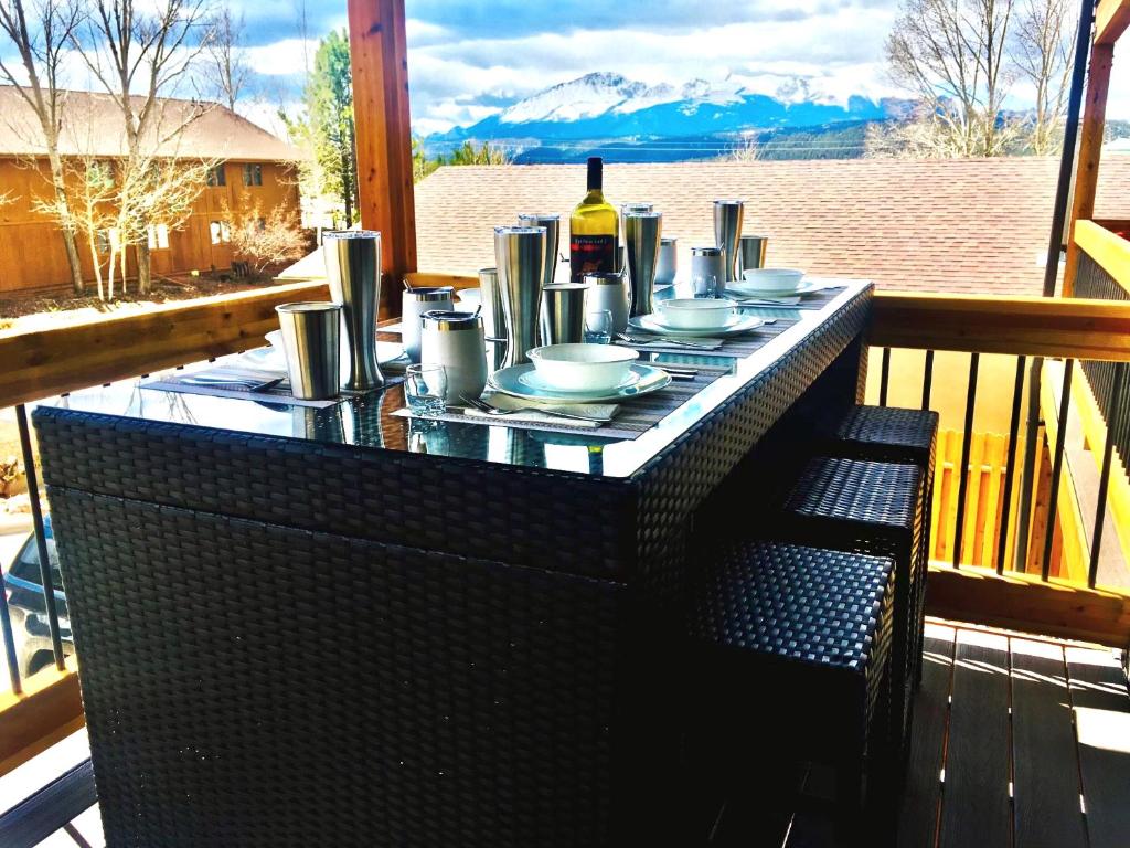 a table with plates and a bottle of wine on a balcony at The Aspen - in WPCO at 8488 ft elevation in Woodland Park