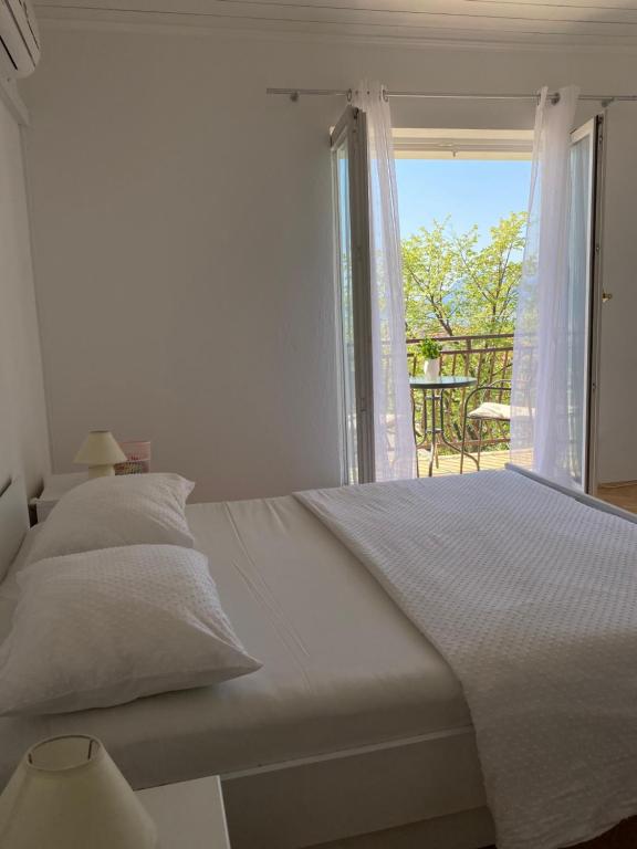 Habitación blanca con cama y ventana en Room for Two, en Baška Voda