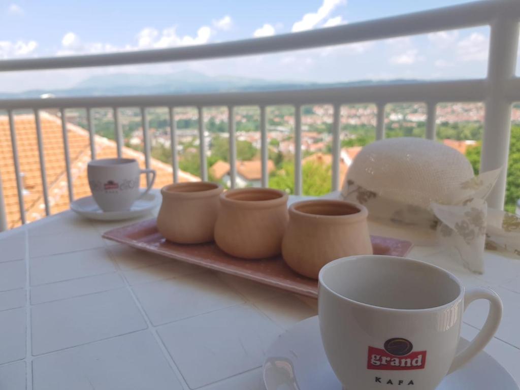 a table with coffee cups on a balcony at Kragić apartman in Soko Banja