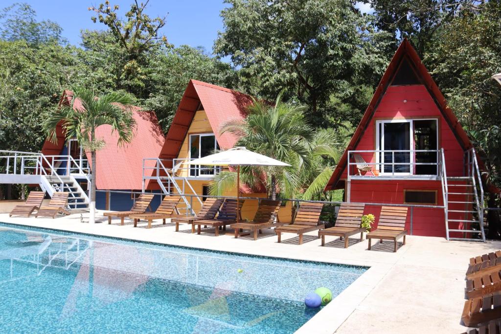 ein Haus mit einem Pool und einem roten Haus in der Unterkunft Greengos Hotel in Lanquín