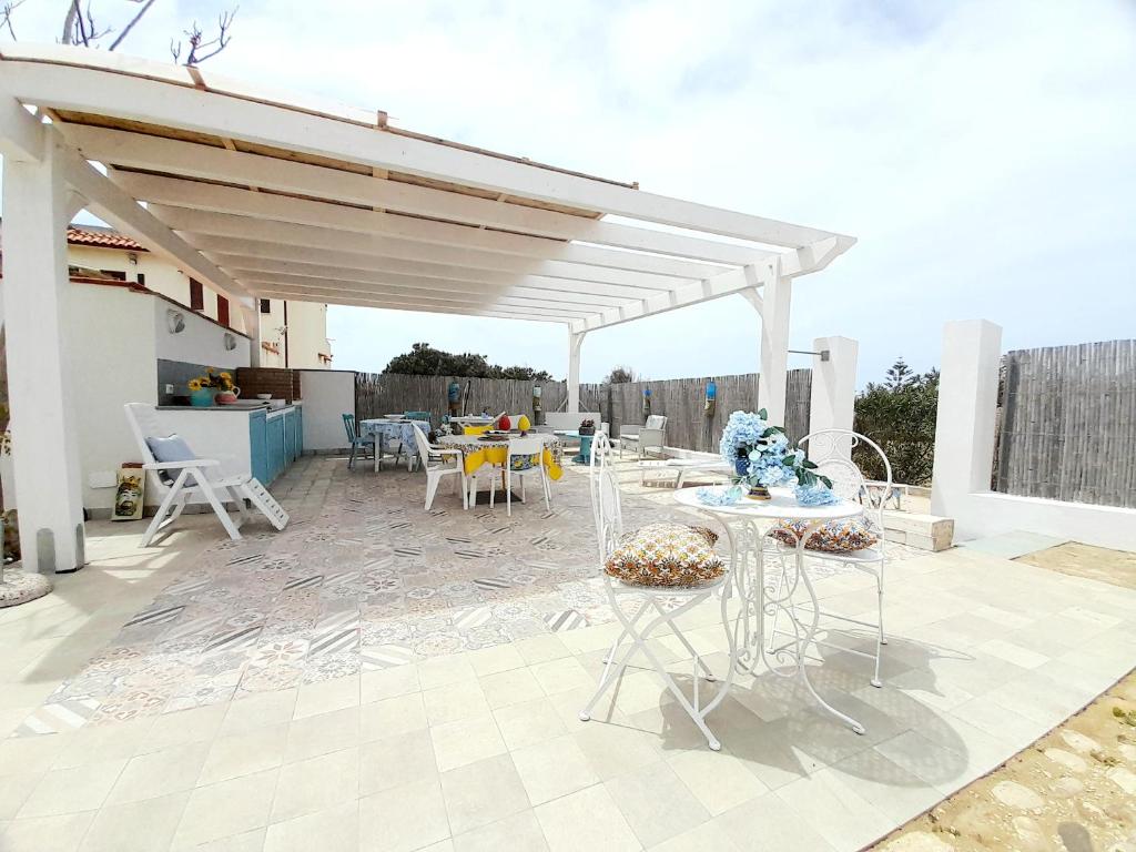 un patio avec une table et des chaises sous un pavillon dans l'établissement La Villa di Eracle, à Licata