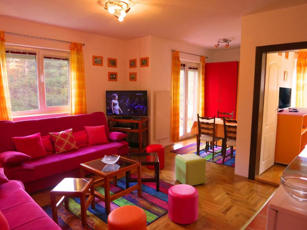 ein Wohnzimmer mit einem Sofa und einem Tisch in der Unterkunft Apartman Happy in Zlatibor