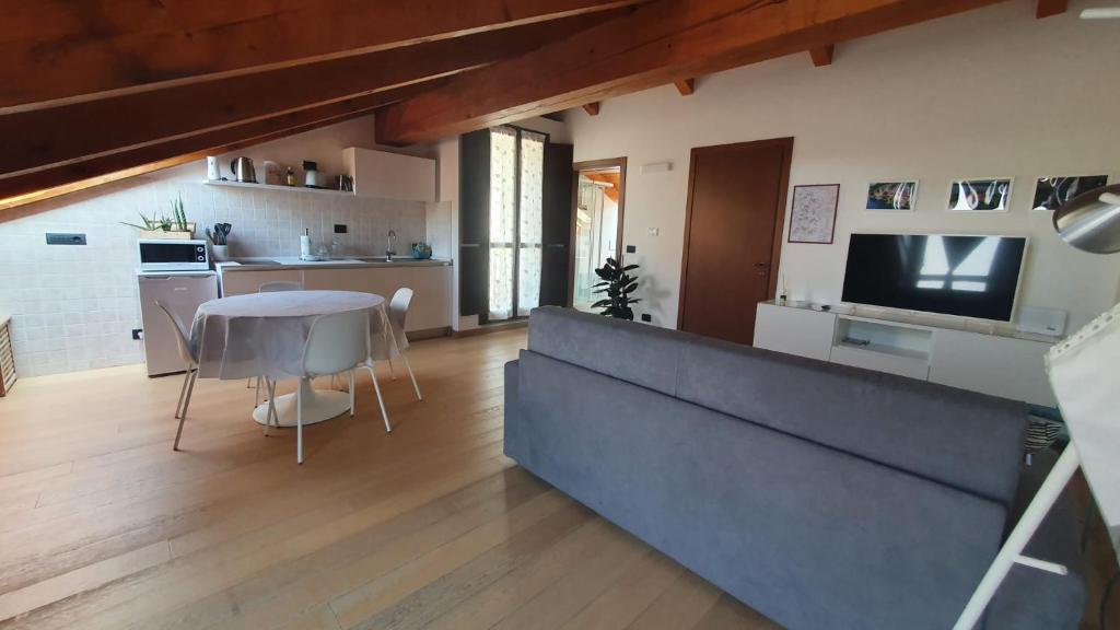 cocina y sala de estar con mesa y TV en Appartamento Residenza Lavinia, en Monforte dʼAlba