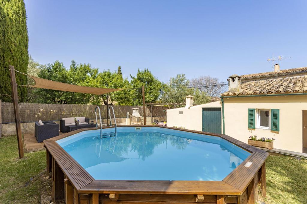 - une piscine dans un jardin avec une table en bois dans l'établissement Can Pere Bec, à Moscari