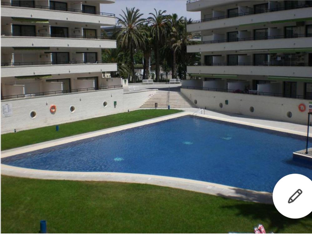 a large blue swimming pool in front of a building at APARTAMENTO CERCA DEL PASEO Y PORT AVENTURA in Salou