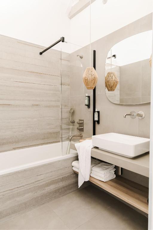 a bathroom with a white sink and a shower at Hôtel Restaurant Les Arnelles in Saintes-Maries-de-la-Mer