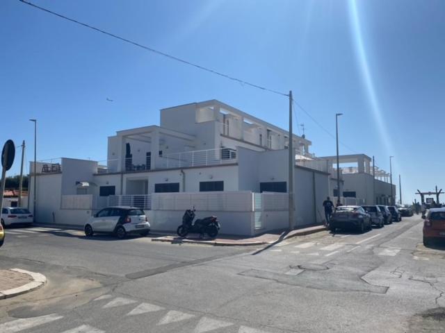 a parking lot with cars parked in front of a building at Casa Vacanza Surf & Kite Focene in Focene