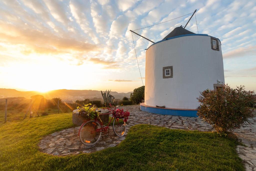 una bicicleta estacionada frente a un molino de viento en Moinho Monte Adão, en Vila Franca do Rosário