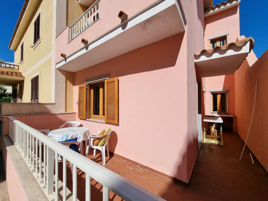 een balkon van een huis met een tafel erop bij La stella rosa sul mare in Santa Teresa Gallura
