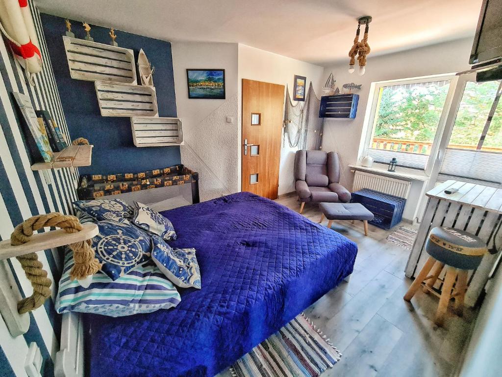 a bedroom with a blue bed and a chair at Agroturystyka Nowy Kraków in Jeżyce