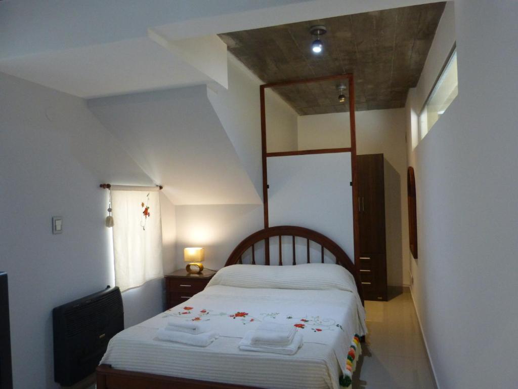 una camera da letto con un grande letto con lenzuola bianche di LAJUACA a San Salvador de Jujuy