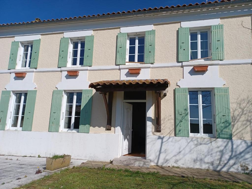 a building with green shutters and a door at Chez Soizic et Patrick in Bords