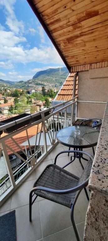 una mesa y una silla en un balcón con vistas en Little house, Mandrina 13, en Sarajevo
