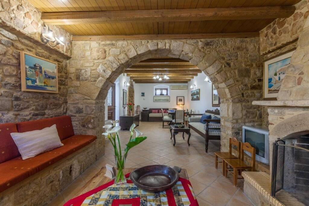 sala de estar con pared de piedra y chimenea en Villa Lavender en Mitrópolis