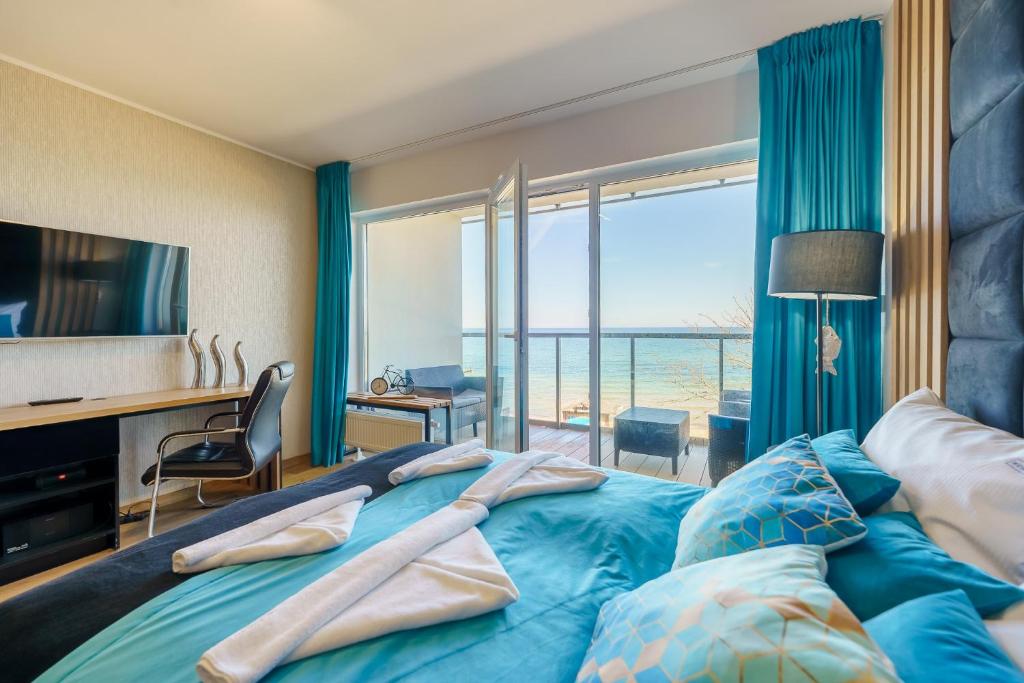 a bedroom with a bed with a view of the ocean at Ustronie Apartments - Apartamenty KOMFORT, widok na morze, Parking in Ustronie Morskie