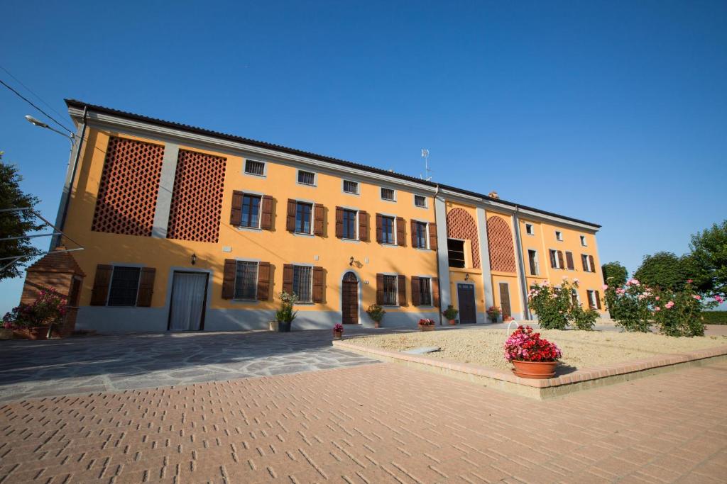 a large yellow building on a brick street at Agriturismo Monrabbioso in Cereseto