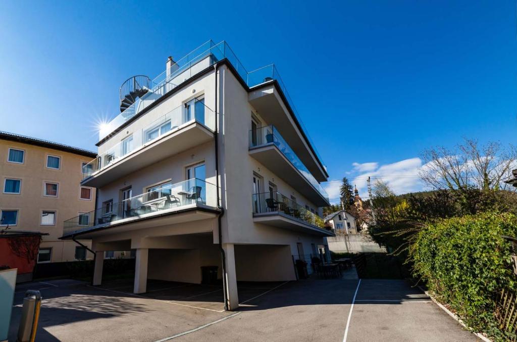 Biały budynek z balkonem na boku w obiekcie Luxury Apartment Monte Carlo w mieście Pörtschach am Wörthersee