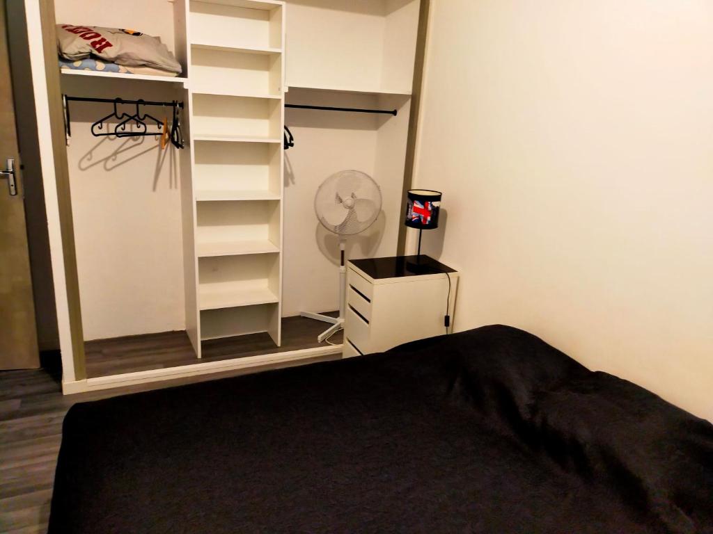 1 dormitorio con 1 cama y armario con ventilador en Appartement en duplex au 3ième étage sans ascenseur, en Hyères