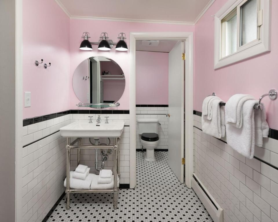 Baño rosa con lavabo y aseo en Sapphire Motel Midtown Bozeman en Bozeman