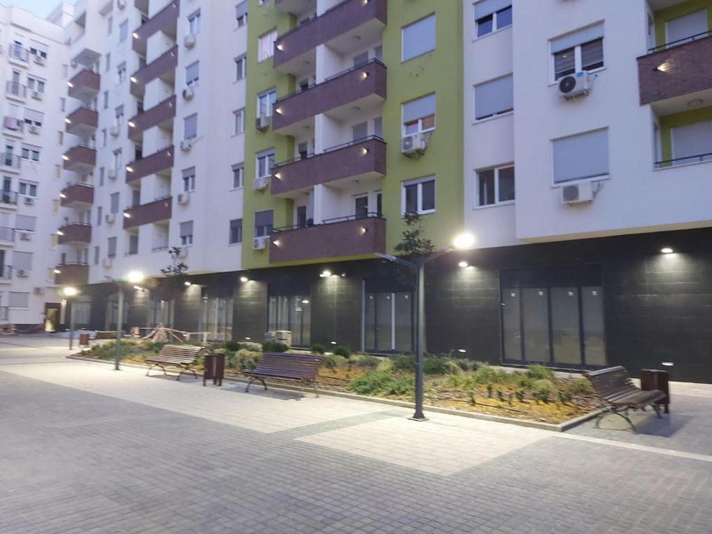 a row of benches in front of a building at Center Sunrise Apartment in Novi Sad