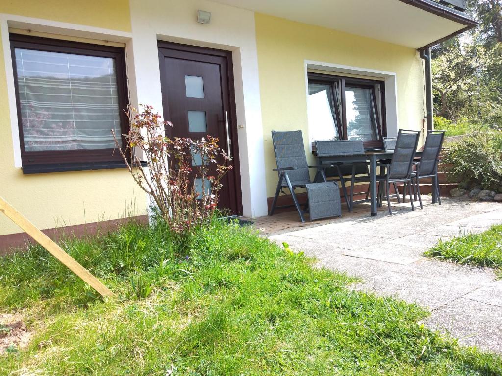 a house with a patio with chairs and a table at Helena Ferienwohnung in Hemfurth-Edersee