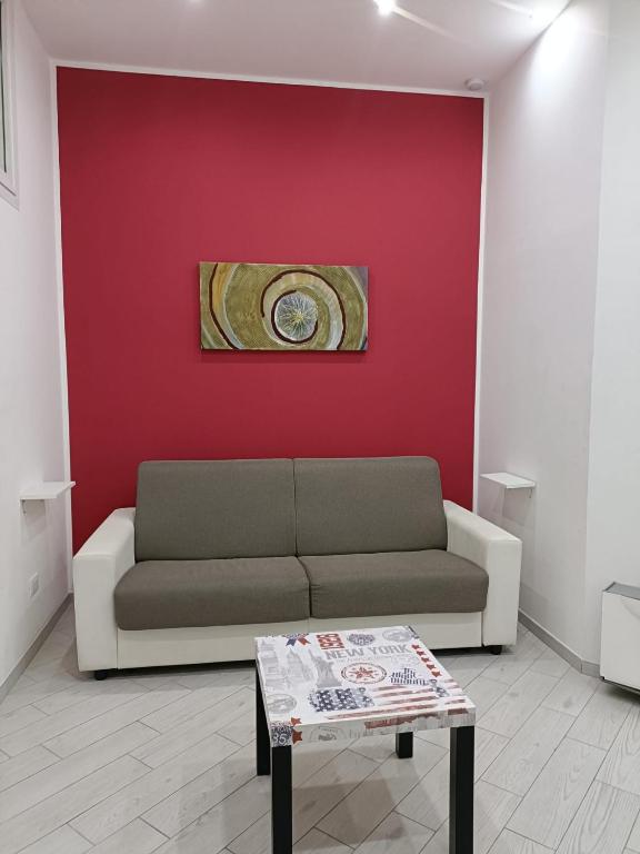 a living room with a couch and a red wall at Il filo di Jordi in Savona