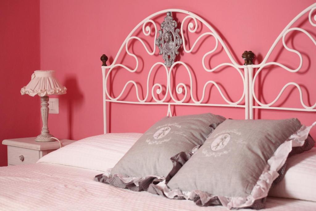 RevereにあるB&B La Torre a Revereのピンクの壁のベッドルーム1室(白いベッド1台付)