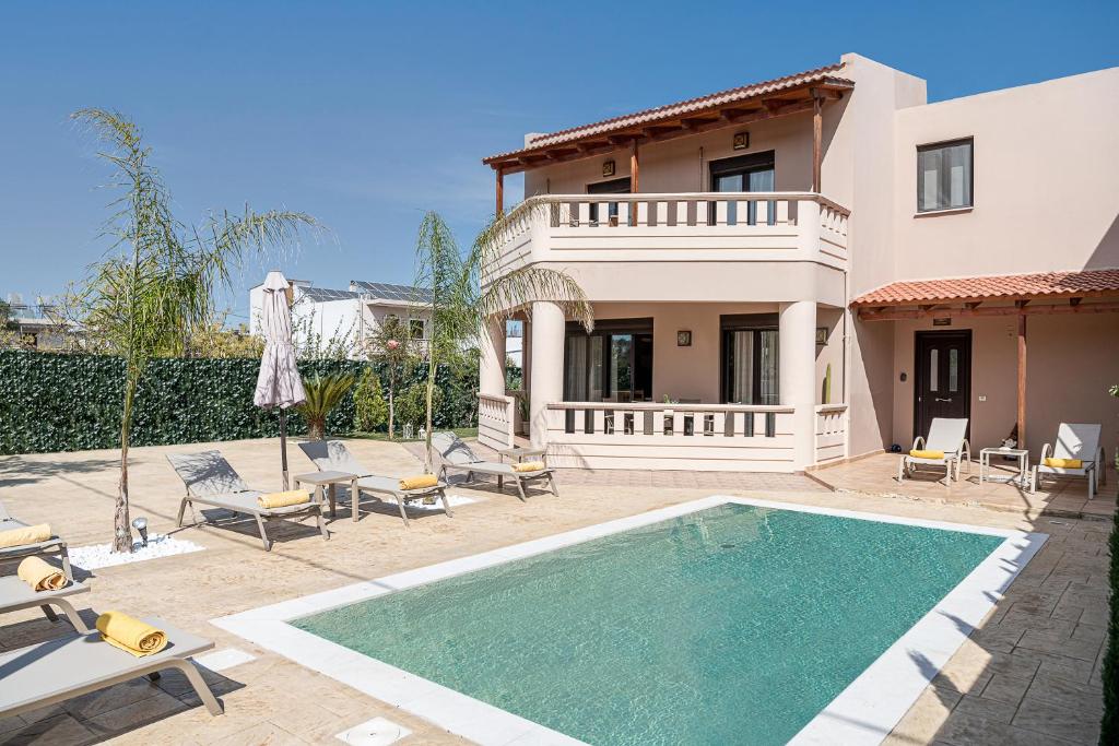 a house with a swimming pool in front of a house at Villa Fanouris in Chania