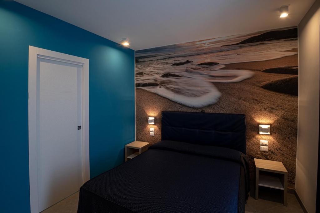 - une chambre avec des murs bleus et un lit orné d'une peinture dans l'établissement Hotel La Sorgente HS, à Paestum