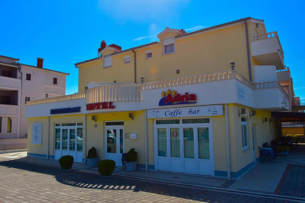 un edificio con un bar cafetería en una calle en Hotel Adria, en Kaštela