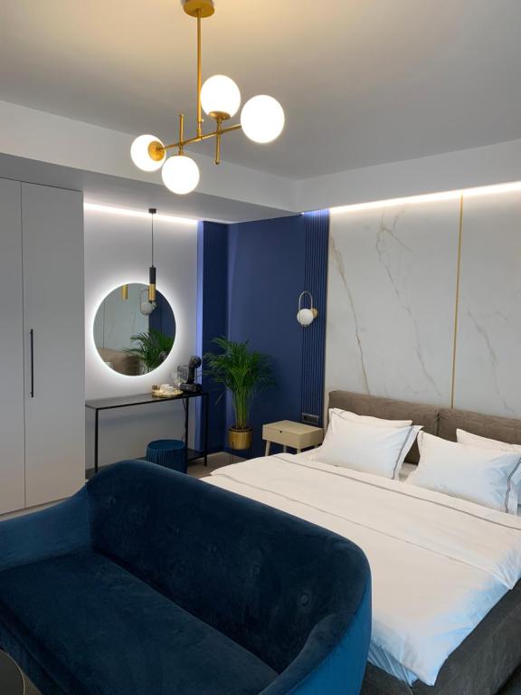 a bedroom with a large bed and a blue couch at Luxury Saphir Gold Mamaia Nord in Mamaia