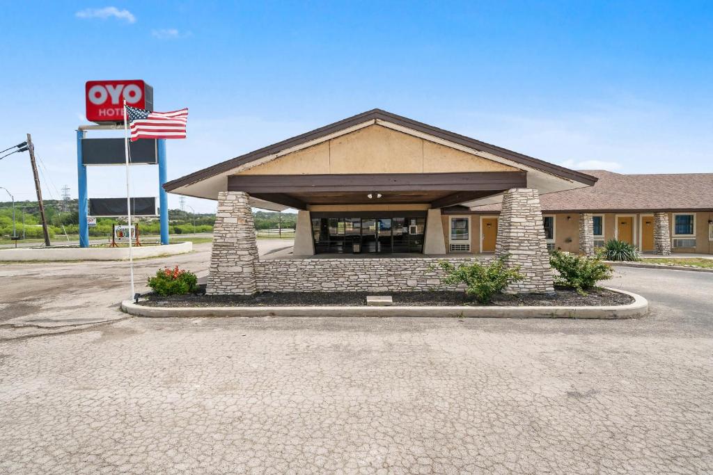 a gas station with an american flag in front of it at OYO Hotel Junction TX I-10 in Junction