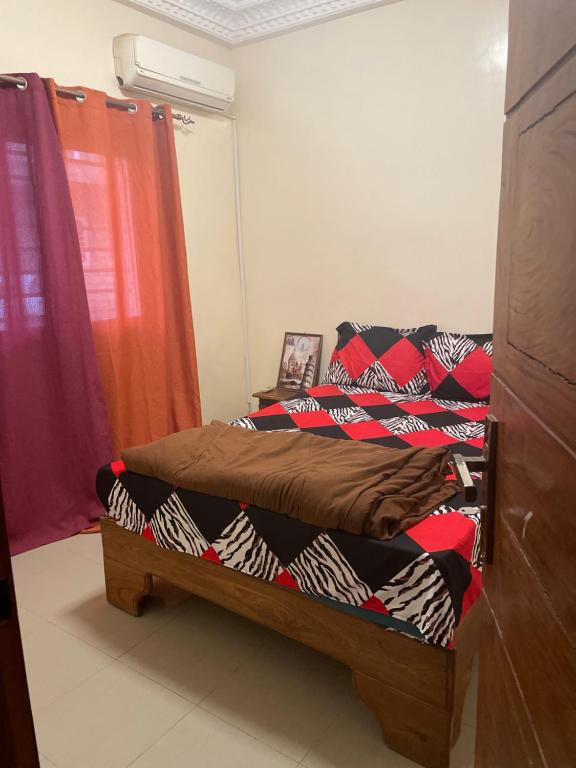 RESIDENCE MERCURE في داكار: غرفة نوم مع سرير مع لحاف ملون