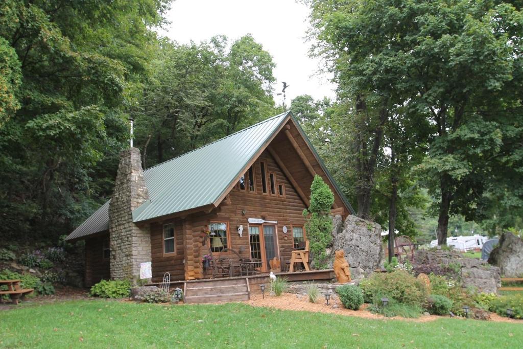 una piccola baita di tronchi con tetto verde di Carries Cabin a Harpers Ferry