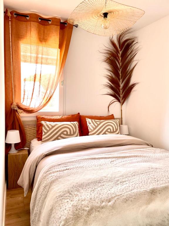 a bedroom with a large bed and a window at L'Escapade Bohème in La Grande-Motte