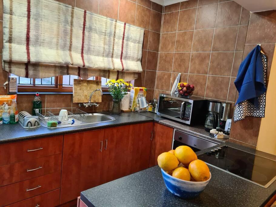a kitchen with a bowl of fruit on a counter at Quaint, quiet retro charm in Johannesburg