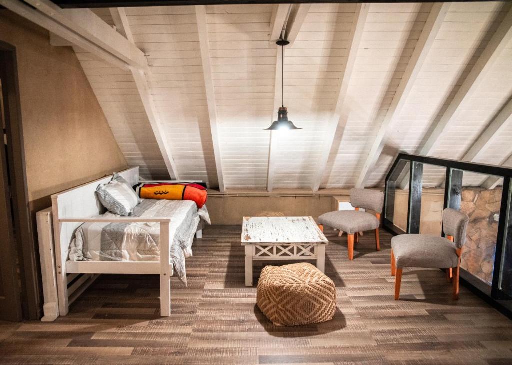 Habitación con cama, mesa y sillas. en Casas De Montaña Las Leñas Los Molles en Los Molles