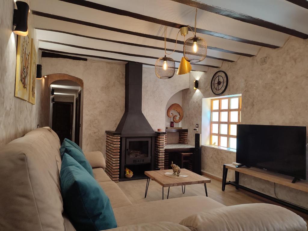 a living room with a couch and a fireplace at Casa el Autillo Alcalá del Jucar in Alcalá del Júcar