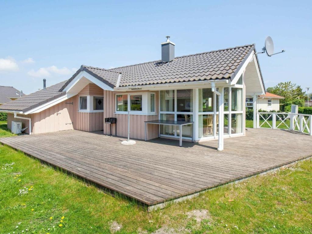 a house with a large deck in front of it at 6 person holiday home in GROEMITZ in Grömitz