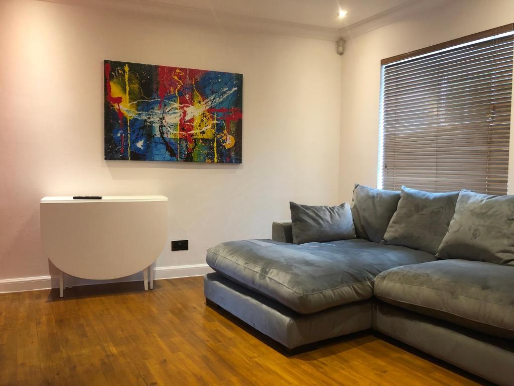 a living room with a couch and a painting on the wall at Lovely 1-bedroom flat near city centre in Perth