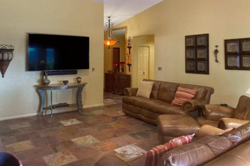 uma sala de estar com sofás de couro e uma televisão de ecrã plano em Four Queens in Chapel em Sedona