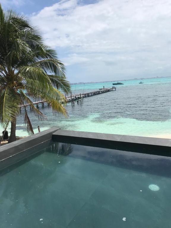 a swimming pool with a view of the ocean at Maria's Kan Kin in Isla Mujeres