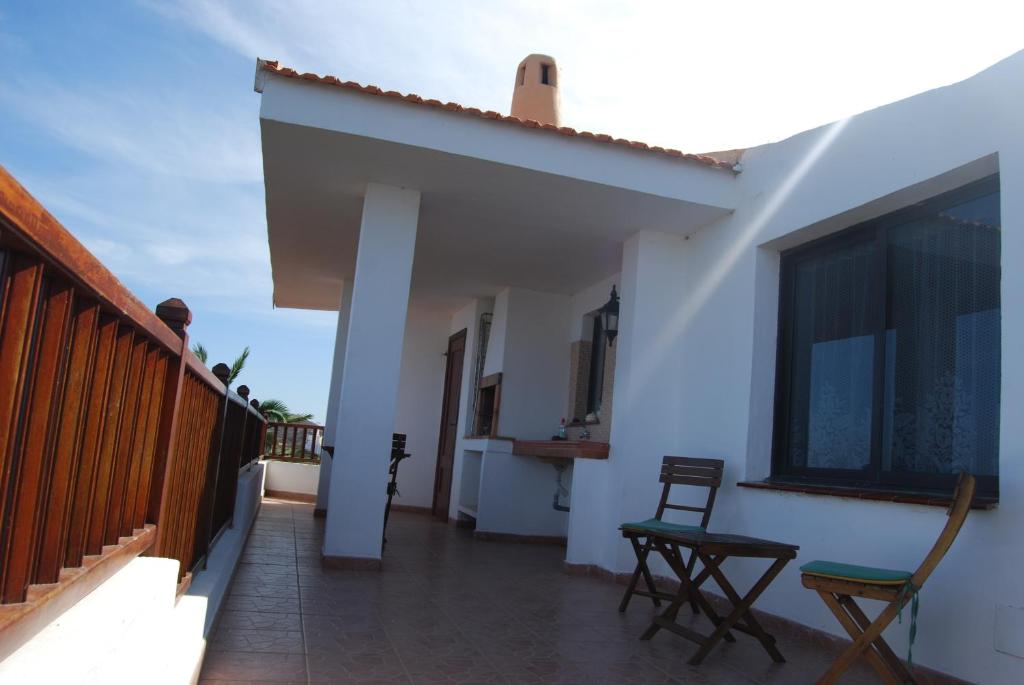 un balcón de una casa blanca con 2 sillas en Holiday home Doña Lola, en Valverde