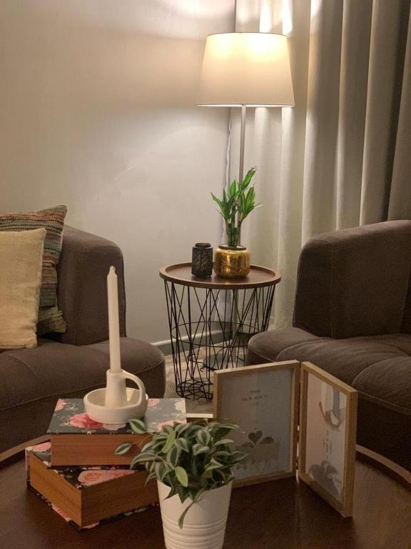 uma sala de estar com um sofá e uma mesa com uma vela em شقة في مدينة الملك عبدالله الاقتصادية حي الشروق em King Abdullah Economic City