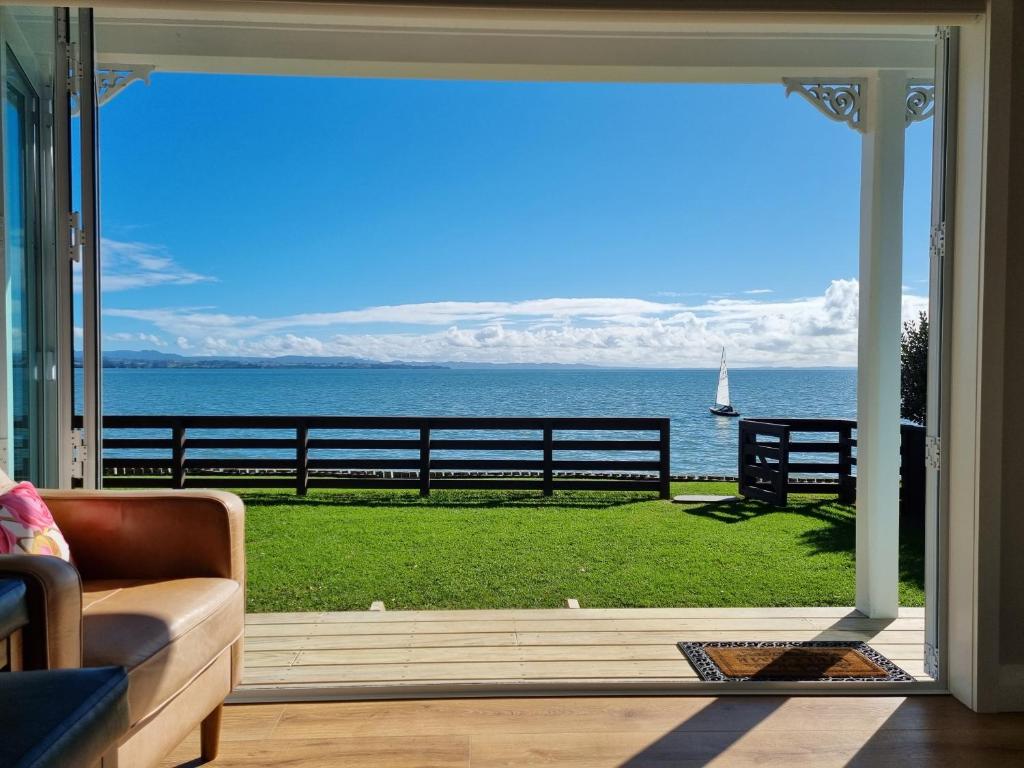 a living room with a view of the ocean at Red Rock Cottage, beachfront luxury in Clarks Beach