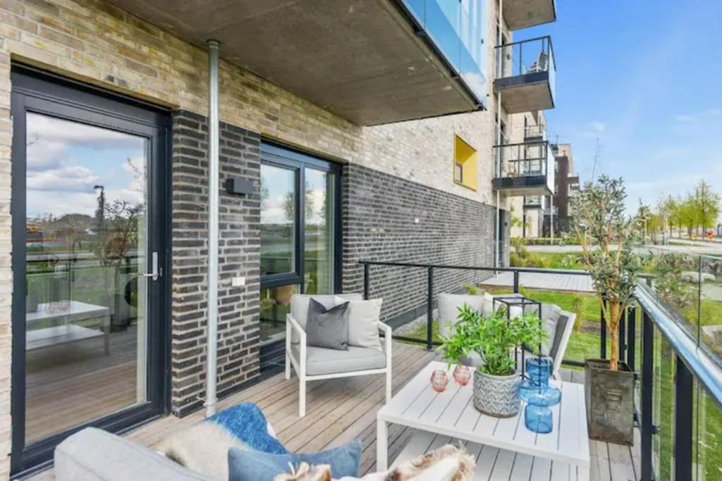 einen Balkon mit einem Sofa und einem Tisch in der Unterkunft Scandpoint Apartment Fornebu Near Sea front with outdoor walk! in Stabekk