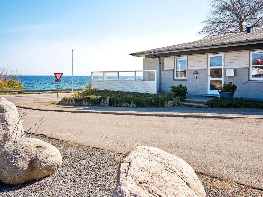 a house with two large rocks in front of the ocean at 4 person holiday home in Allinge-By Traum in Allinge