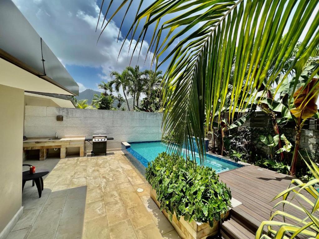 a backyard with a swimming pool and some plants at Garden Oasis 2 Villa With Private Pool in Four Roads