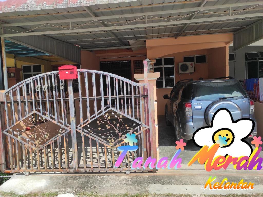un portail en face d'une maison avec une voiture dans l'établissement Yuna Homestay, à Tanah Merah