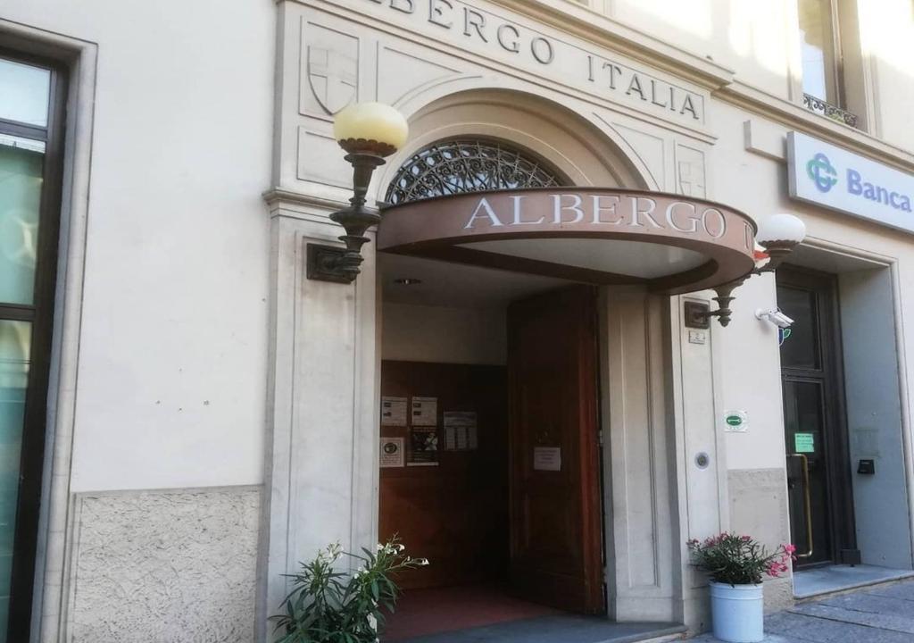 een toegang tot een albergo Italiaans gebouw met een bord erop bij Hotel Italia in Porretta Terme